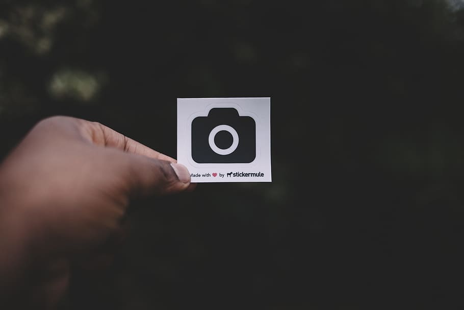 person holding white paper showing camera illustration, person holding card with camera graphic HD wallpaper
