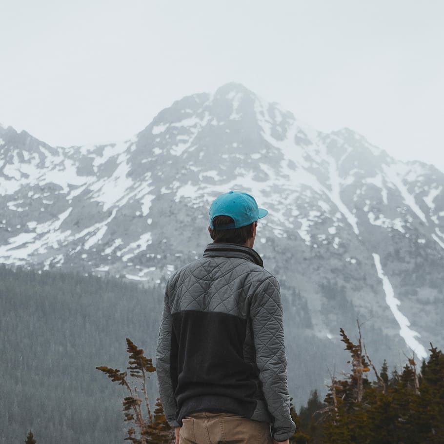 man in gray and black zip-up jacket, person standing in front of mountain HD wallpaper