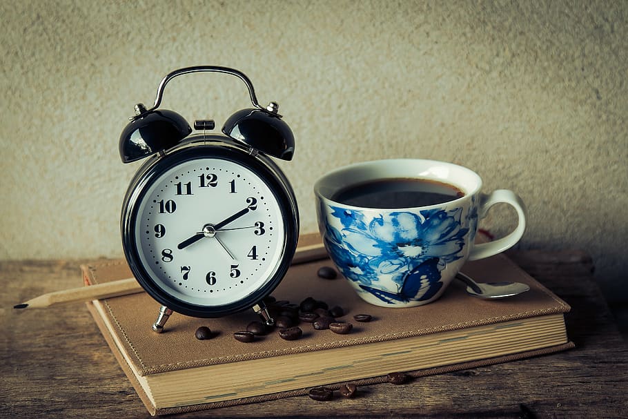 filled white and blue floral ceramic cup with alarm clock, vintage