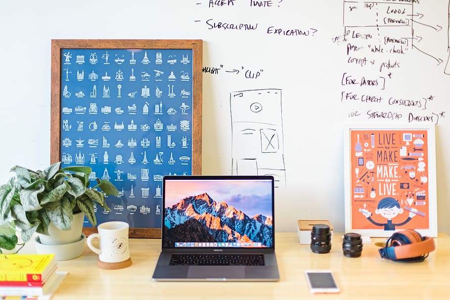 MacBook Pro on brown wooden table beside white mug, turned on MacBook Pro on brown wooden desk HD wallpaper