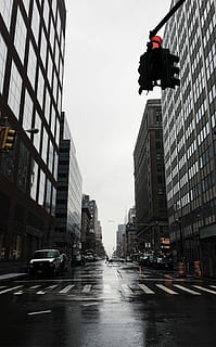 vehicles on grey wet road between buildings during daytime, white vehicle park near pedestrian lane HD wallpaper