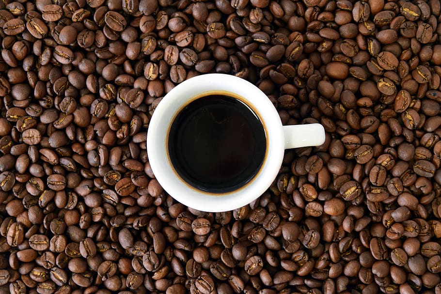 white ceramic teacup filled with coffee on top of coffee bean lot HD wallpaper