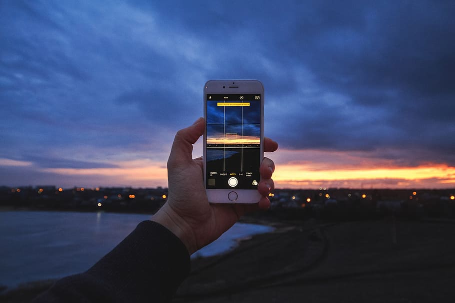 Man photographer using his mobile iPhone smartphone camera at sunset, HD wallpaper