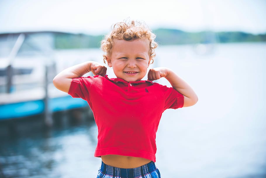 boy wearing maroon polo shirt near body of water during daytime HD wallpaper