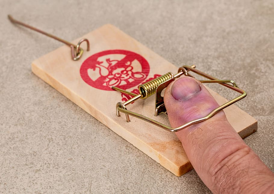 person hands on brown wooden mouse trap, mistake, foolish, hurt