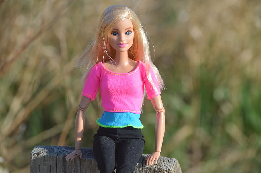selective focus photography of Barbie doll in pink shirt, posing