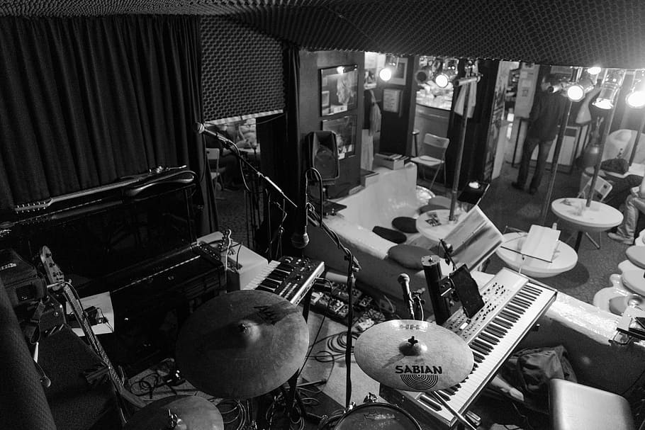 grayscale photo of drum set in music room, stage, live, occurs