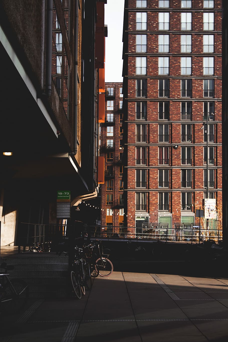 bicycles on concrete pavement, brown concrete building, brick HD wallpaper