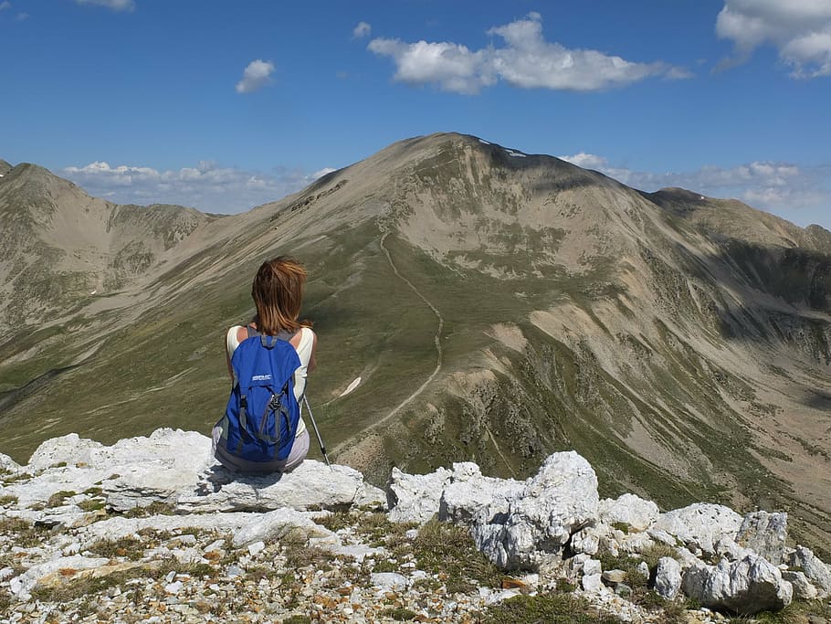person sitting on rock in front on mountain, adventure, cliffs HD wallpaper