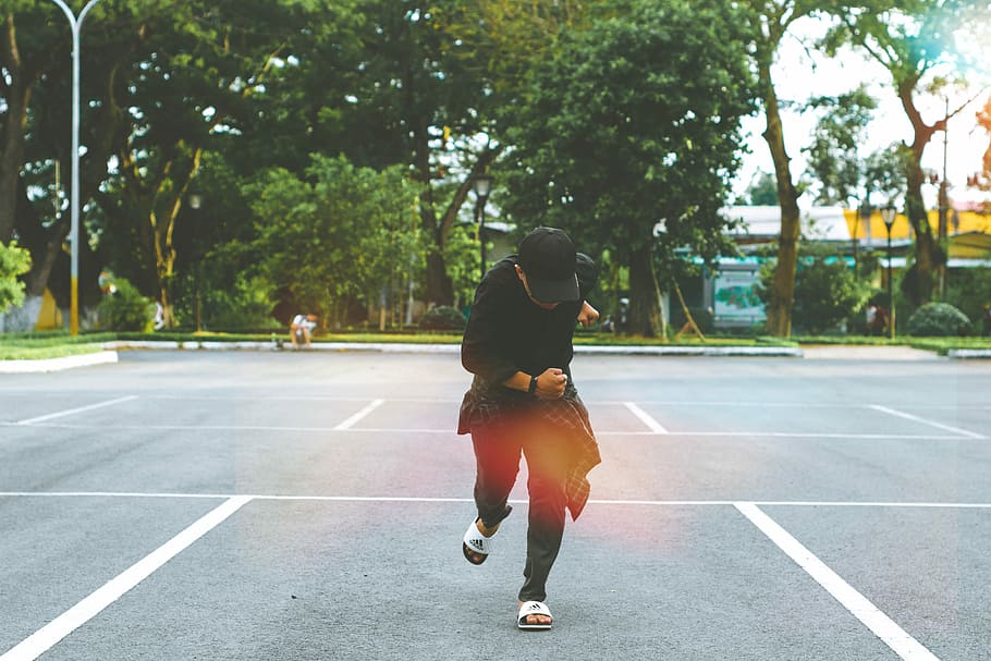 man standing on parking lot, person in black cap, t-shirt, and pants standing on parking spot HD wallpaper