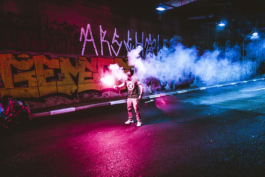person standing holding flare in road, man holding sparkler while standing on street, HD wallpaper