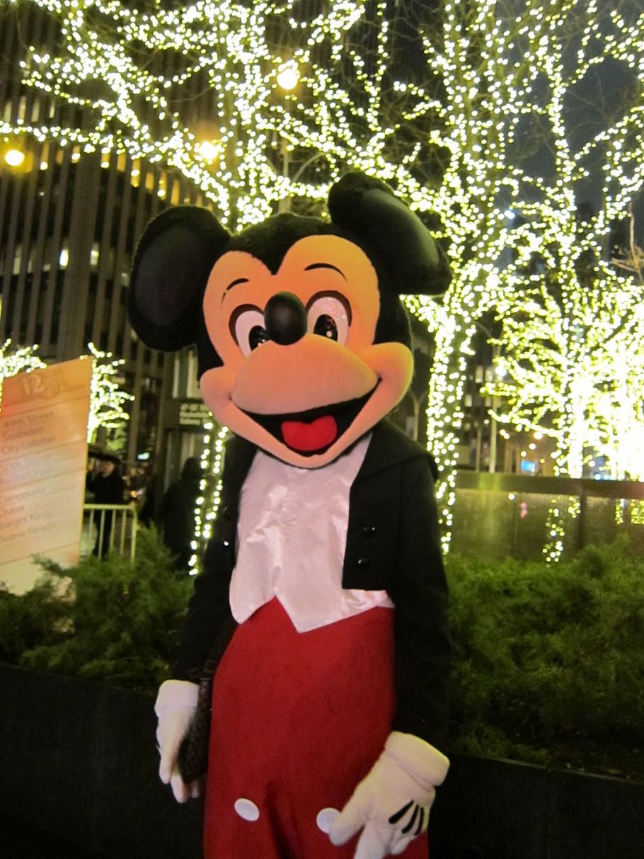 Mickey Mouse mascot in front of LED lighted bare trees, new york city