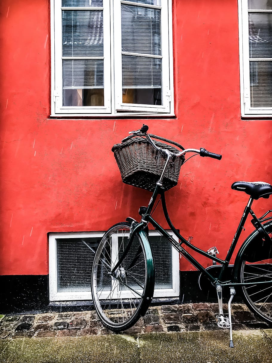 Snowy street with spring mood, black city bicycle beside red wall HD wallpaper