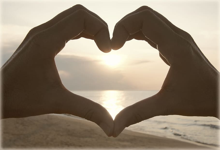 person forming heart by hands near seashore during sunset, beach HD wallpaper