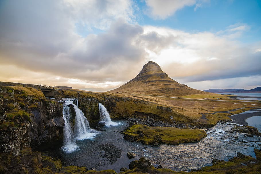 waterfall near brown hill under blue sky, scenery of waterfalls and mountain HD wallpaper
