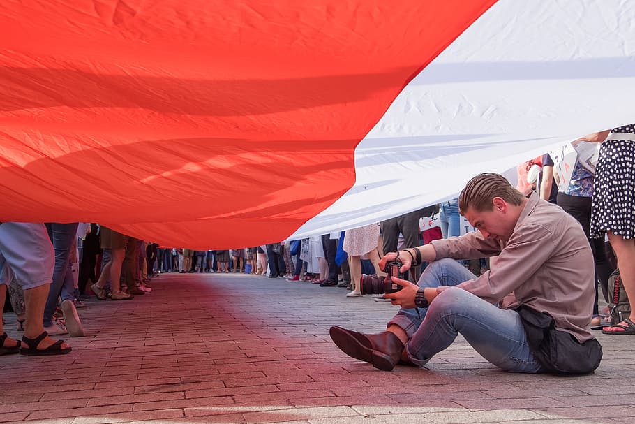 man sitting under flag, poland, polish, photographer, demonstration