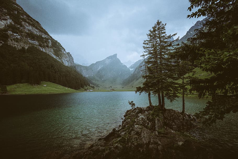 Rainy end at the beautiful “Seealpsee”, green trees and green lake near mountain