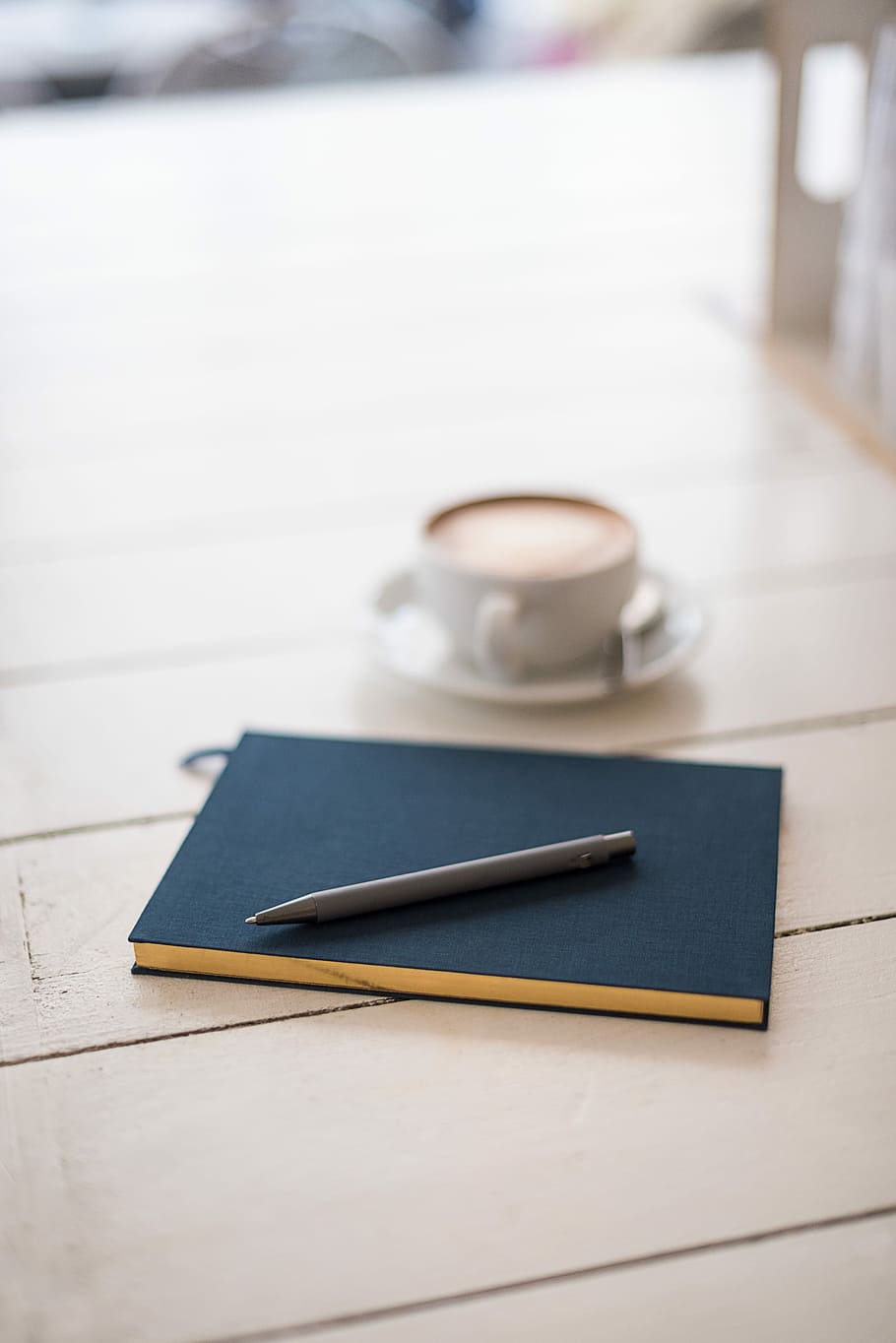 selective focus photography of black pen on book, gray pen on top of blue journal book beside coffee latte HD wallpaper