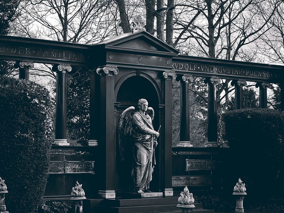 grayscale photo of angel standing and holding sword statue, cemetery