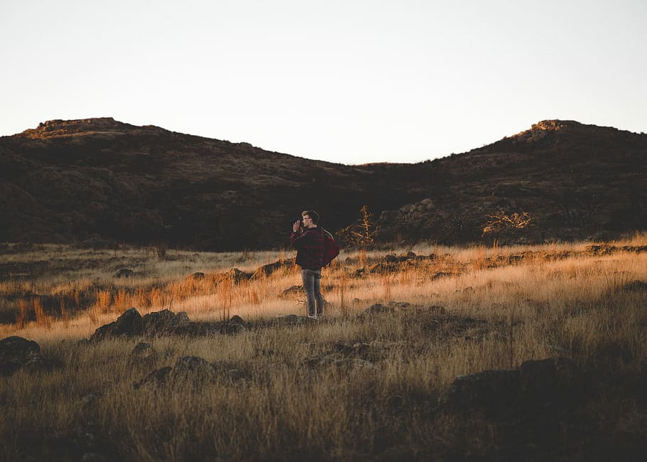 man standing on brown grass field during daytime, mountain HD wallpaper