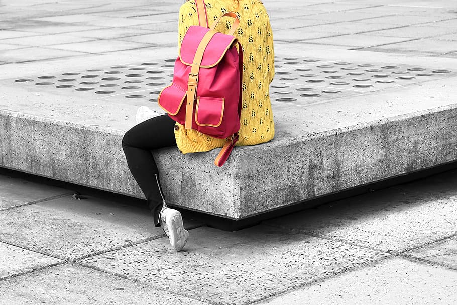 woman carrying pink backpack sitting on the edge concrete bracket, person wearing yellow shirt sitting on concrete floor HD wallpaper