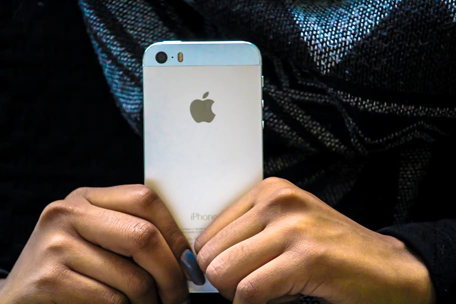 Closeup shot of a person holding their mobile iPhone smartphone in hand HD wallpaper