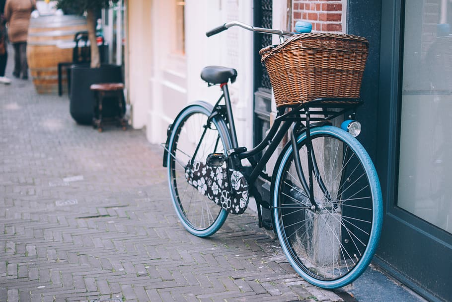 bike parked on the side of the building, black bicycle with brown basket parked beside black door, HD wallpaper