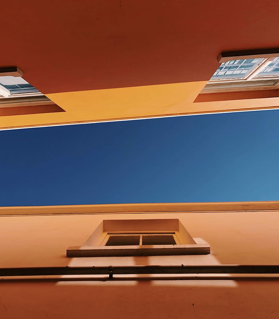 low-angle photography of brown concrete buildings under blue sky at daytime, worm eyes view of orange building HD wallpaper