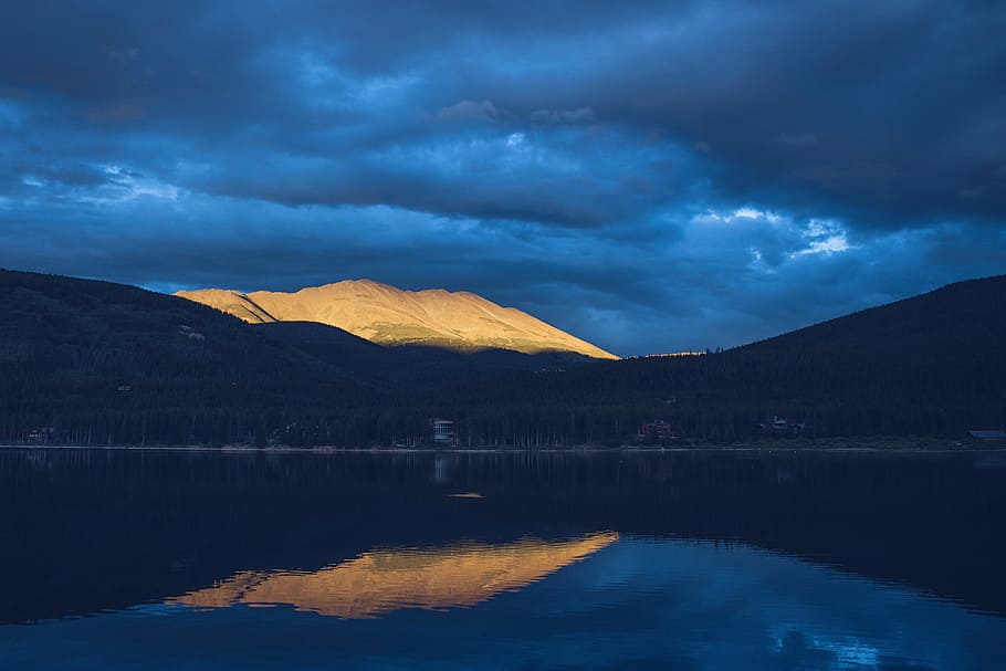 body of water near brown mountain under cloudy sky, reflective photography of mountain HD wallpaper