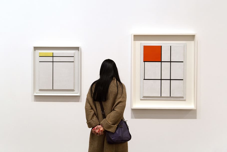 A woman reflects on art by Piet Mondrian in the Tate Modern art gallery in London