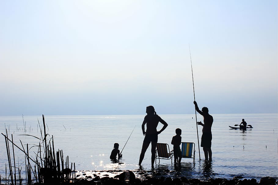 silhouette photo of four person holding fishing rods, sea, ocean