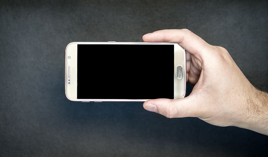person holding brown Samsung smartphone sidewards, screen, horizontal