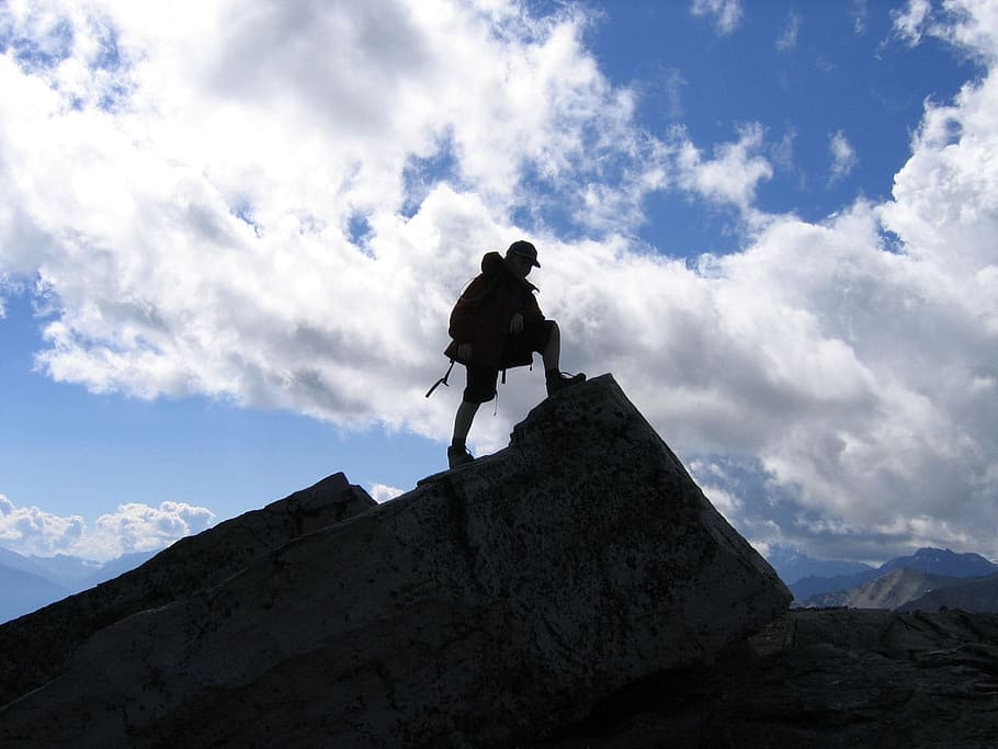 silhouette of man stepping on rock formation at daytime, Profile