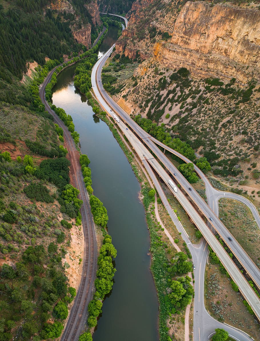aerial photograph of cars on road, river near brown valley with trees and road HD wallpaper