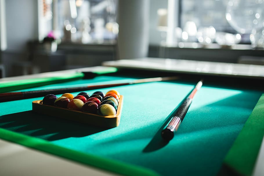 Billiard balls on green table with billiard cue, nobody, time
