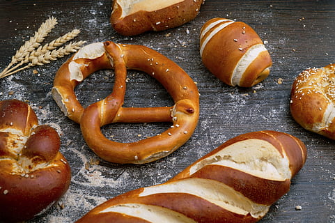 flat lay photography of breads, pretzels and breads on brown pad HD wallpaper