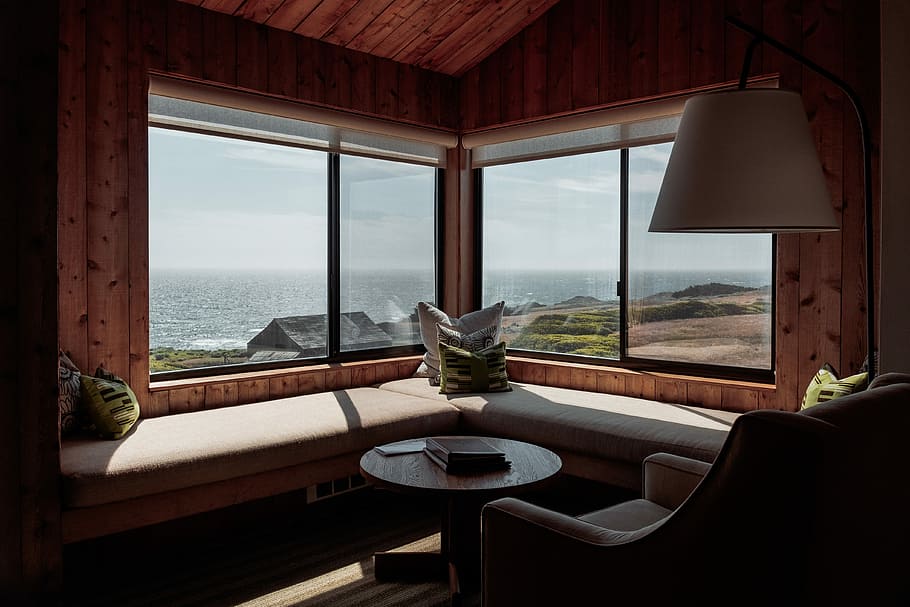 Relaxing view of Pacific Ocean, round brown wooden table and sofa HD wallpaper
