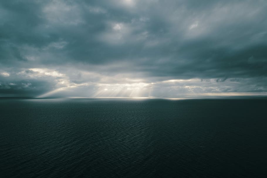 time lapse photography of clouds, body of water under crepuscular rays HD wallpaper