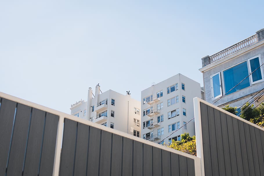 high-rise white concrete building under blue sky during daytime, low angle photo of white concrete building HD wallpaper