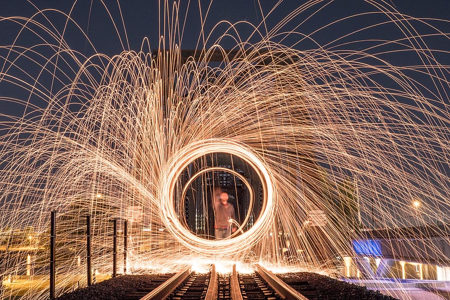 man in front of train railroad steel wool photography, fire HD wallpaper