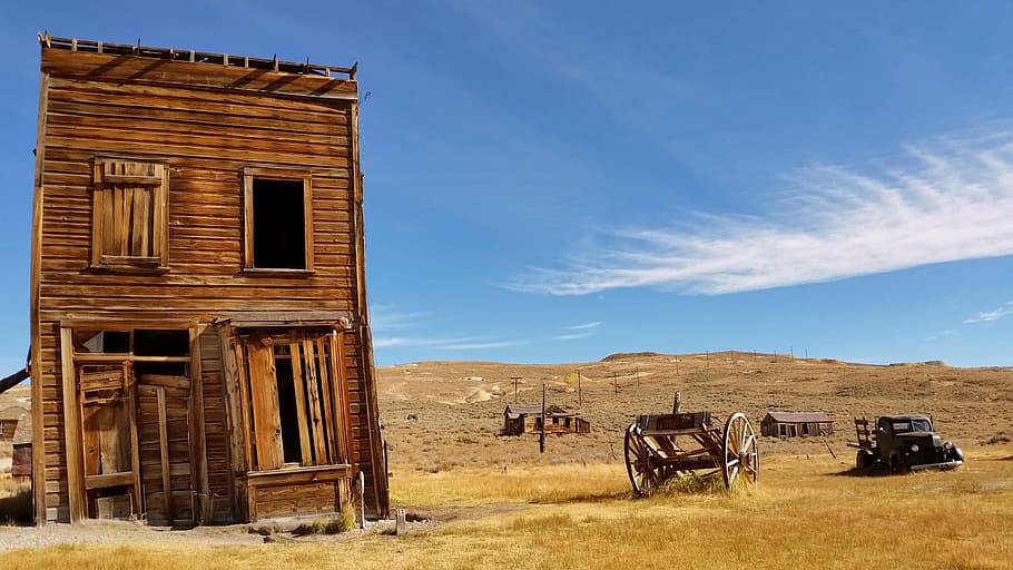 brown 2-storey house near wagon, brown shack near brown grass field and wagons, HD wallpaper