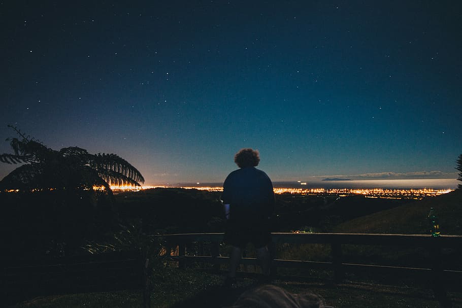 silhouette of man wearing blue top and black shorts, man standing near fence HD wallpaper