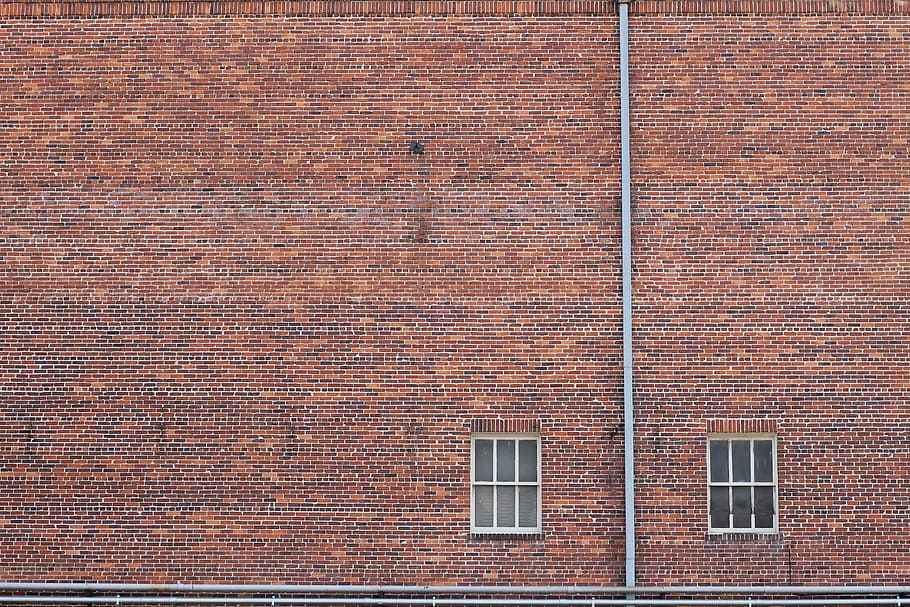 two closed window doors, brown brick wall with white window panes