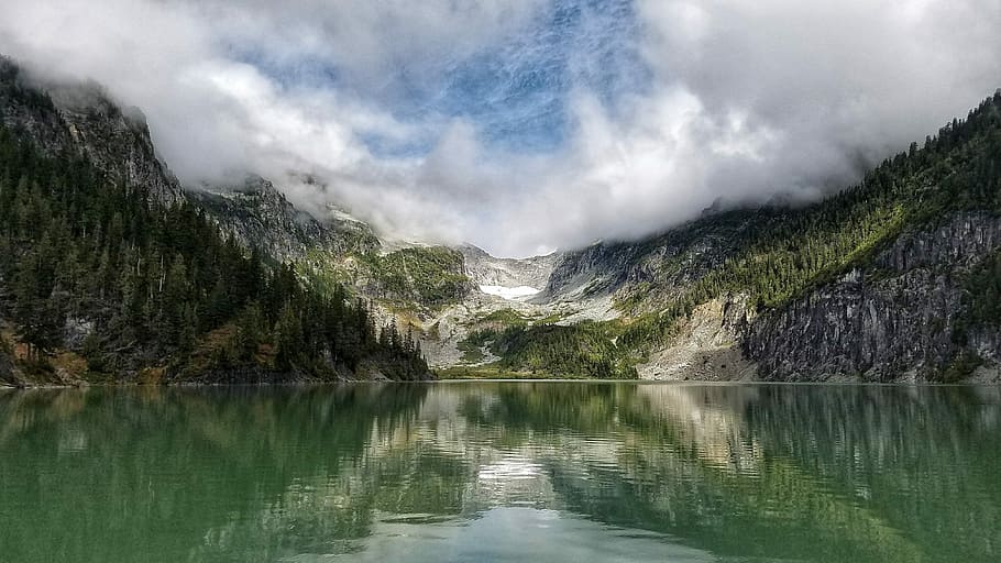 landscape photography of mountain surrounded by pine trees and body of water, body of water near mountain screenshot HD wallpaper