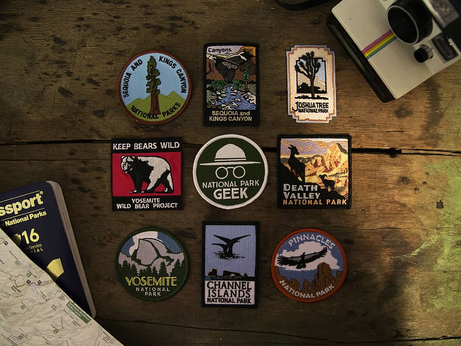 assorted posters on wooden surface, nine assorted badges on table