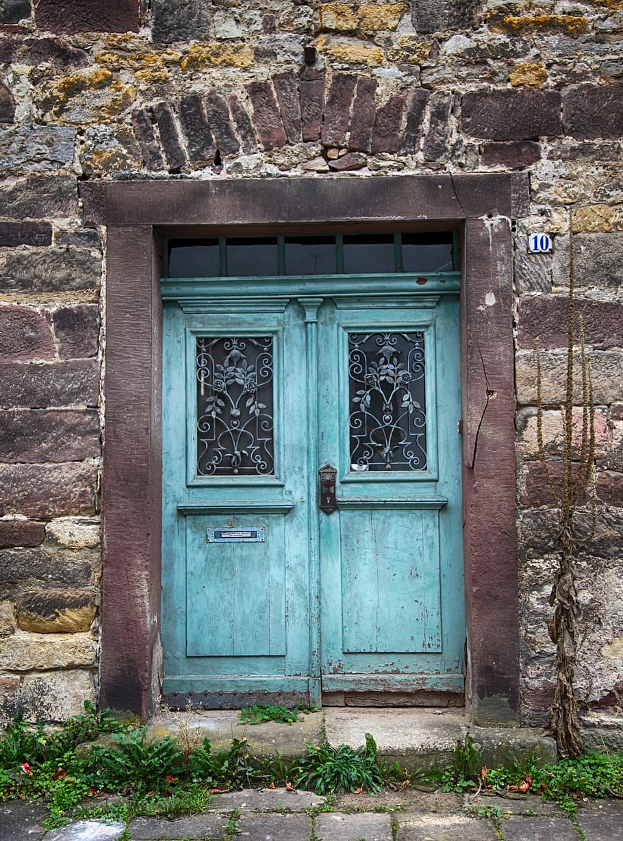 gray and black concrete building with teal wooden doors closed, HD wallpaper