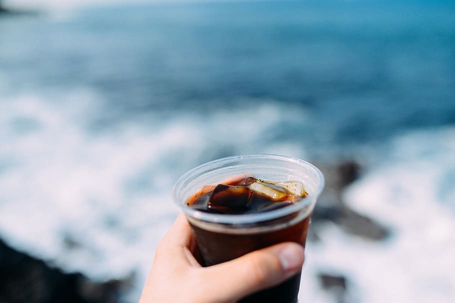 person holding clear cup with black liquid and ice, person holding clear cup HD wallpaper