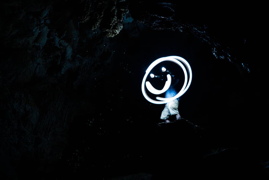 Smile through the darkness, man standing inside cave photo, night