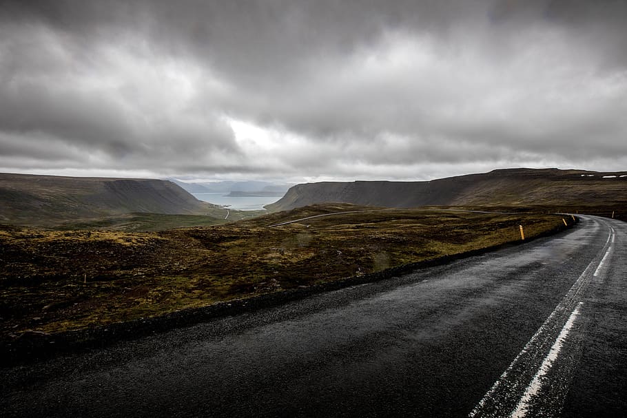 gray asphalt road near mountains under cloudy sky during daytime, asphalt road under gray clouds during daytime HD wallpaper