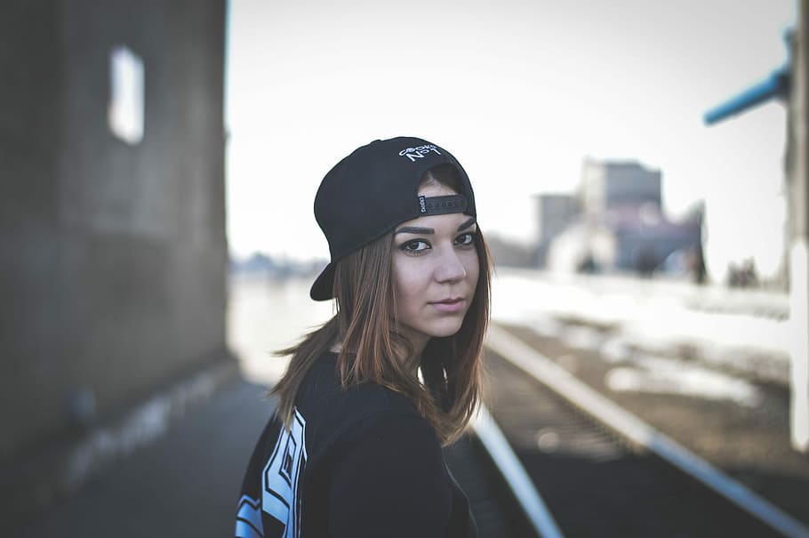 shallow focus photography of woman in black shirt wearing black cap HD wallpaper